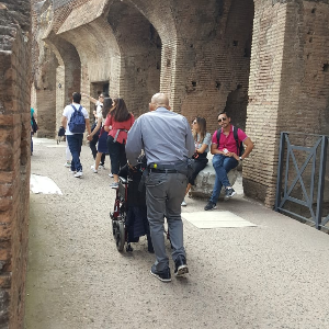 assistace pushing wheelchair in Colosseum