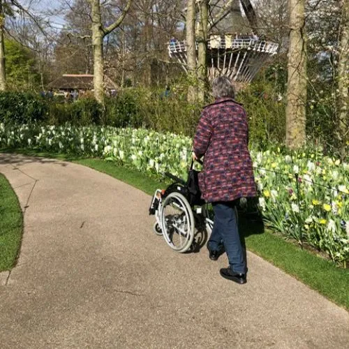 Wheelchair user and companion strolling through Keukenhof