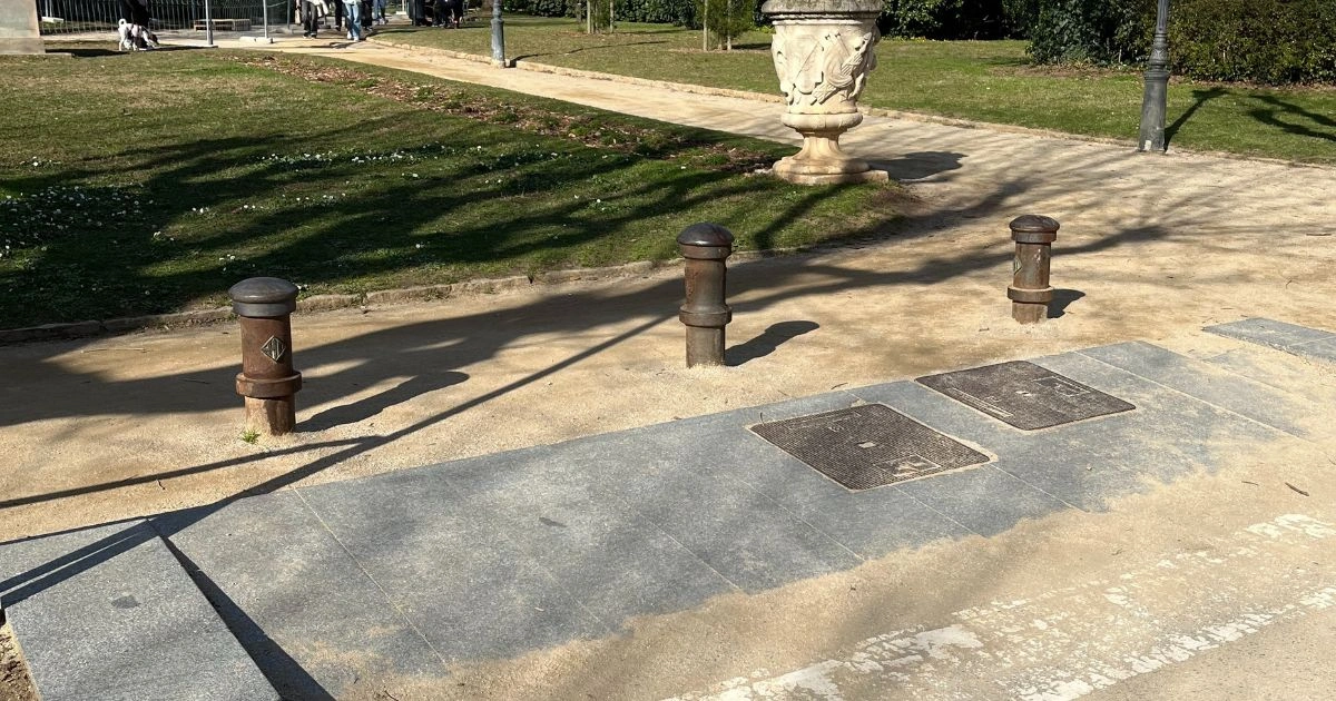 posts at a ramp that goes up to a gravel path