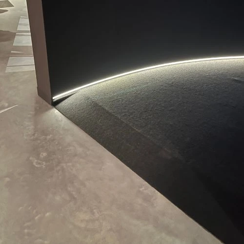slope into darker part of the exhibition, with a led strip at the bottom
