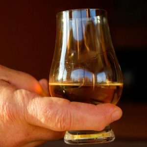 Hand holding glass of whisky
